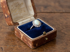 box A vintage cluster ring, features an opal centre stone, measures 8.5x6mm, in a mille grain setting.
