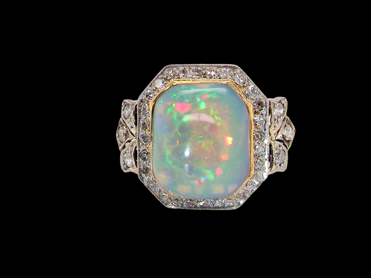 cabouchon cut opal shown is cushion shaped, measures 15x13 (5.78 carats) displaying a mass of vibrant colours, from flashes of fireglow orange, greens, and lavender purples.

