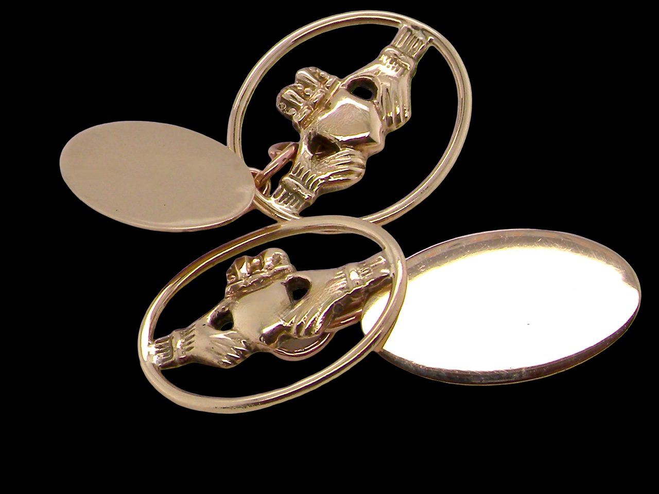 Gold Claddagh ring with two oval settings on a black background