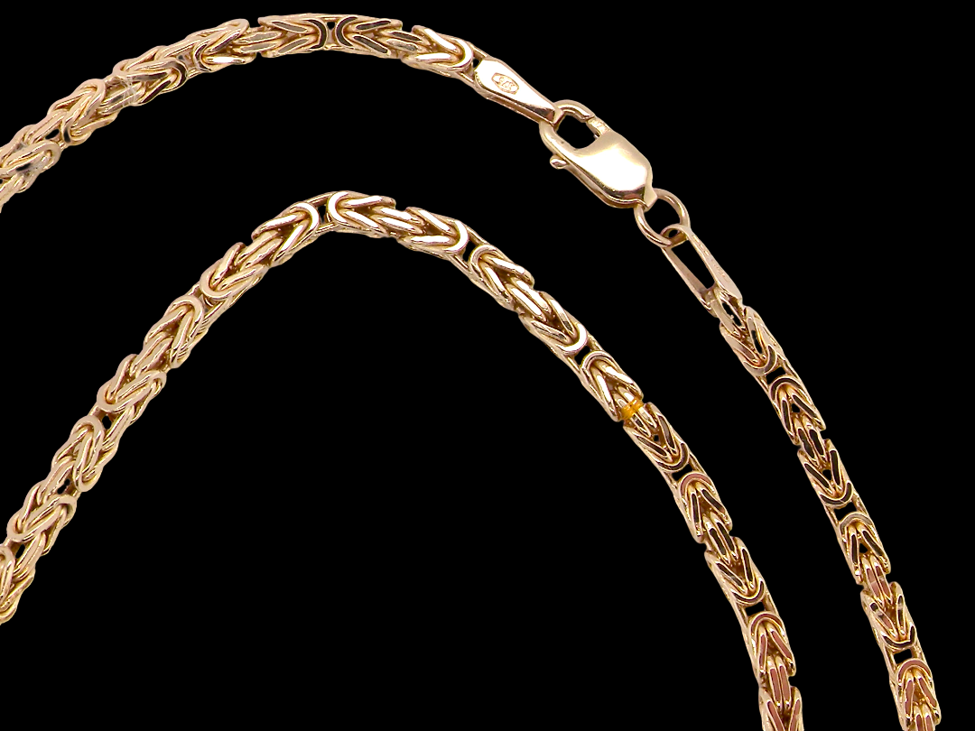 A close-up of a gold rope chain necklace with a lobster clasp, shown against a solid black background.