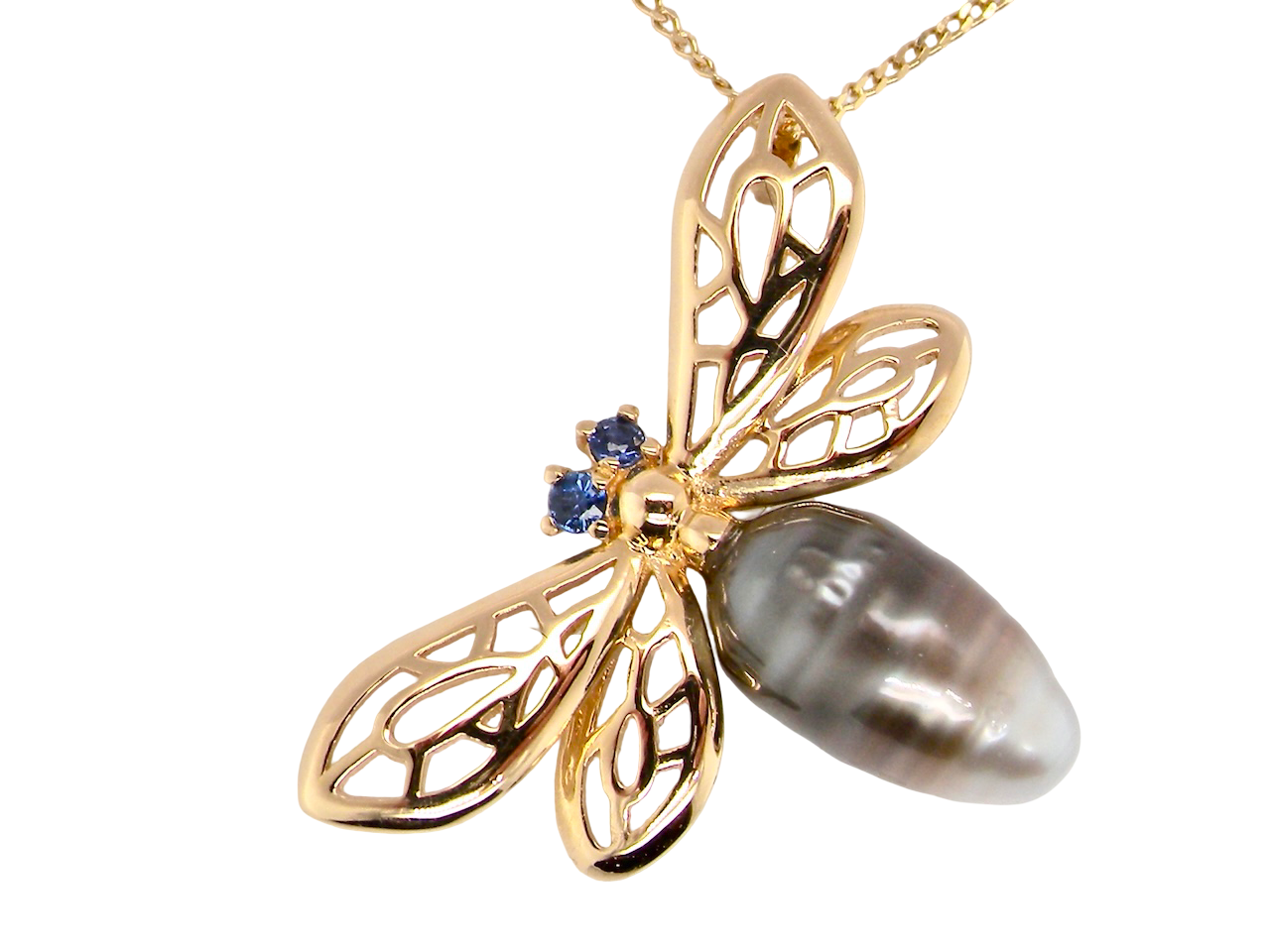 close  double winged dragonfly. The body is a baroque shaped pearl, shades of grey, brown to black 