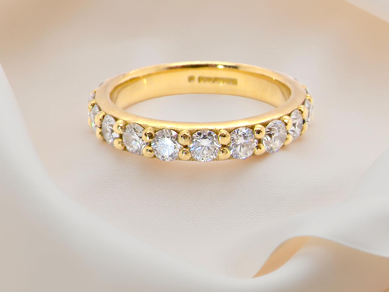 close eternity ring is crafted in 18ct gold and set with fourteen round brilliant-cut white diamonds.