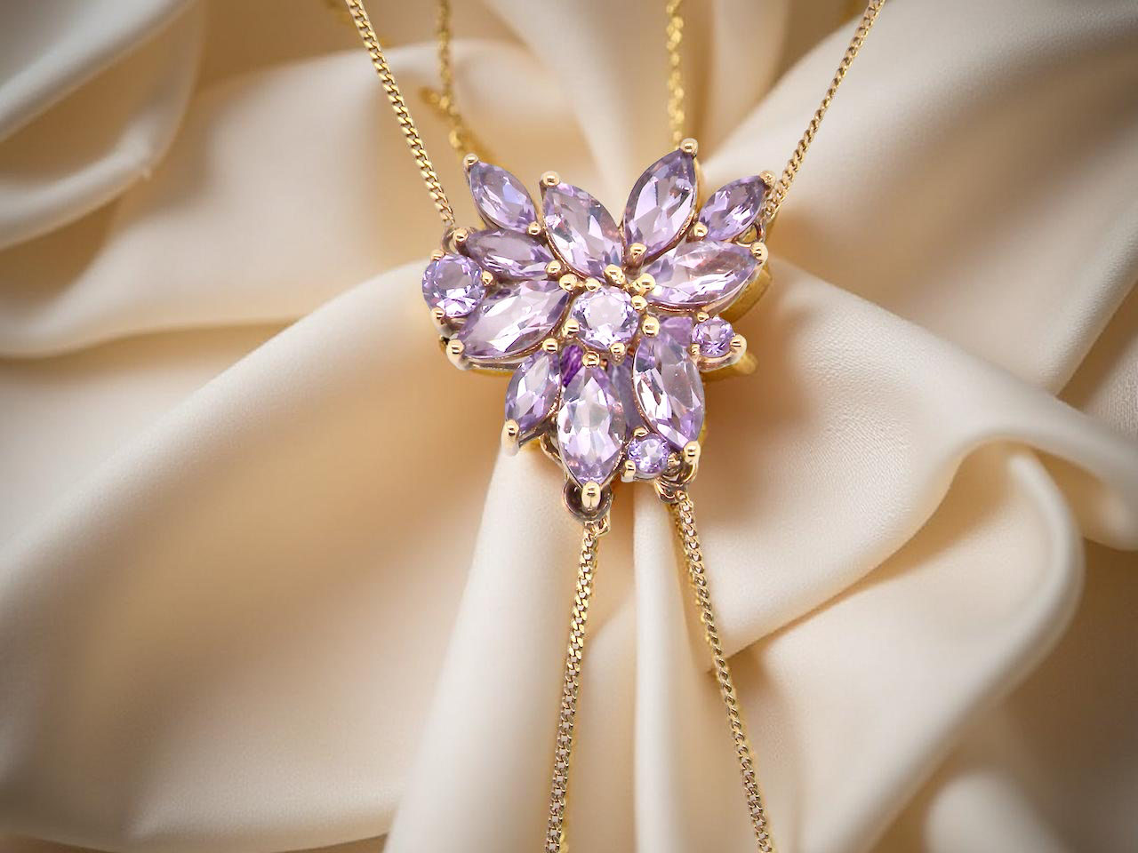 Purple gemstone necklace on a beige fabric background