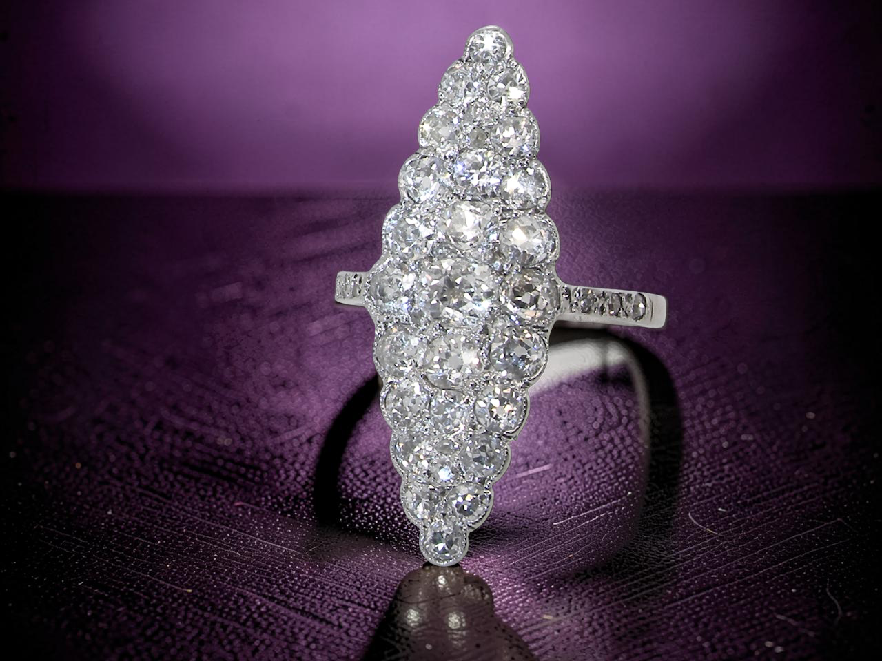 close view This is a striking marquise-shaped diamond cluster ring with a very classic, vintage-inspired look.