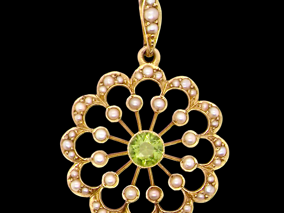 pendant from the Edwardian- Age of Elegance-

The centre stone- a round peridot 5mm diameter, mille grain set. A satellite perimeter of twelve seed pearls, each 2.4mm. The outside border is scalloped shaped and each crescent is set with tiny seed pearls.