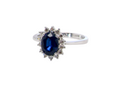cluster ring featuring a striking mid–dark blue oval-cut sapphire at its centre, measuring (estimated 1.25 ct).