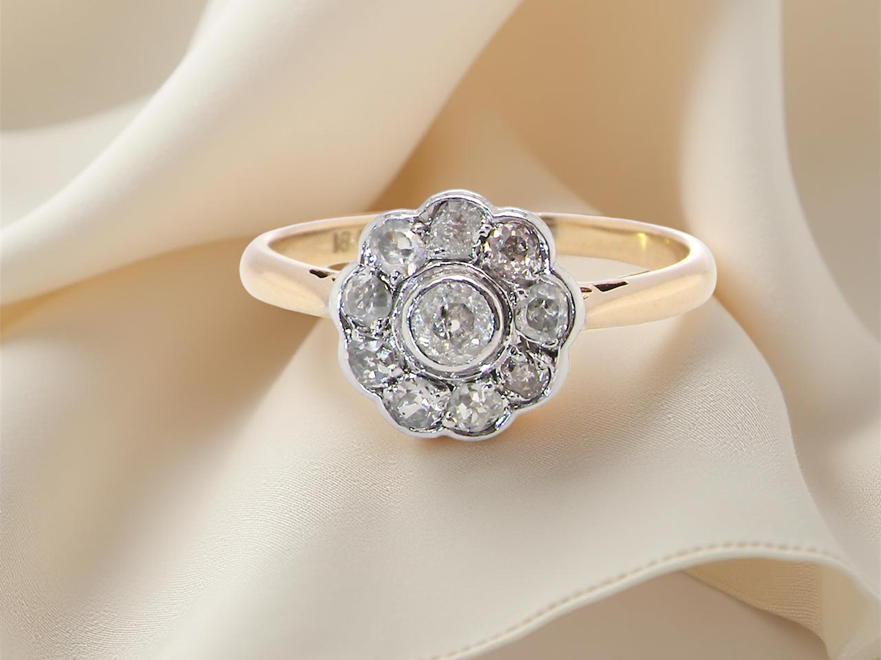 early 20th-century vintage diamond cluster ring, featuring a classic daisy-shaped head set with old brilliant-cut white diamonds.