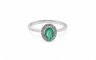 white gold ring with a green gemstone on a white background