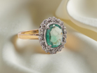 enchanting cluster ring that features  an oval emerald, 