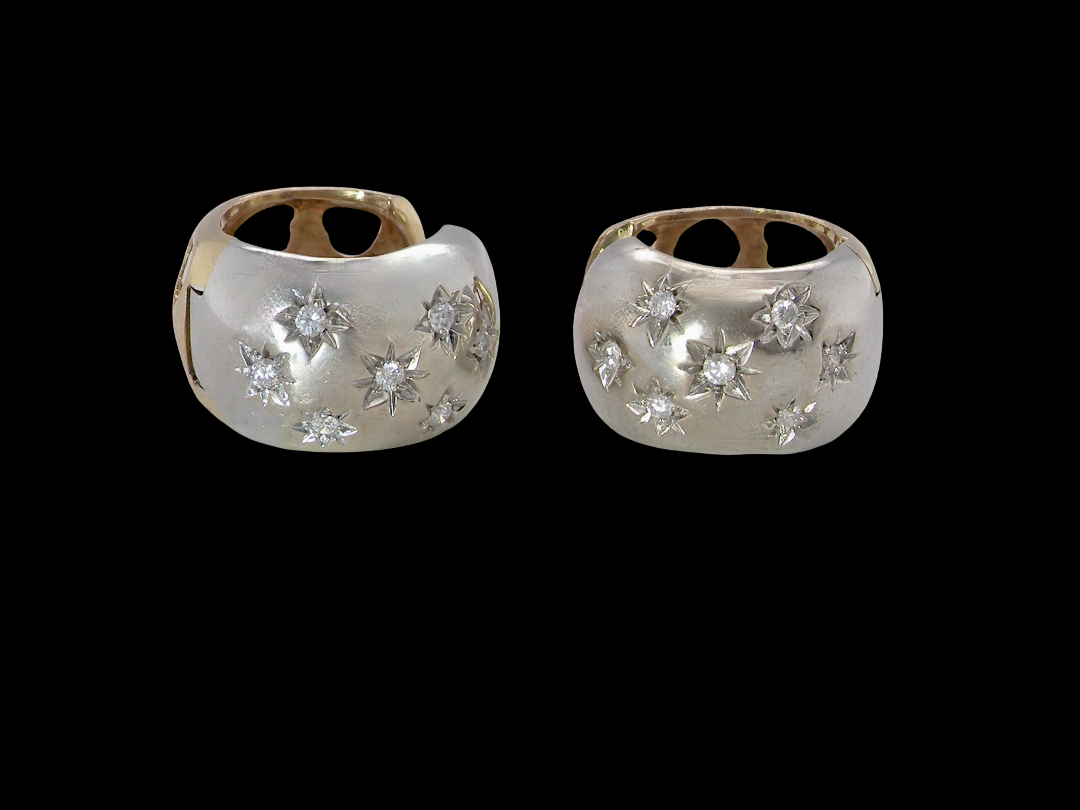 A fine pair of cuff style hoop earrings. The front part is 18 carat white gold * set with seven small white diamonds, 
