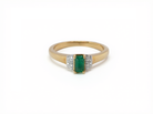 An emerald cut emerald and diamond ring