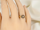 hand A 15 carat gold dress ring. The centre a small seed pearl, 3mm diameter. Surrounded by six sapphires, 
