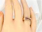 A 9 carat Gold Crossover Ring with Rubies and Diamonds on a Hand