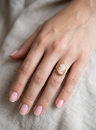 hand A 9 carat gold dress ring that features a cameo shell. Carved with the head of a young woman. Measures 20x15mm.