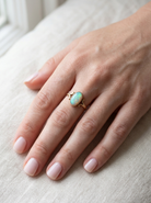 hand A 9 carat gold dress ring that features an oval shaped opal. Measures 12x6.7mm, with a&nbsp; very good play of colour across the white background. Mille grain setting
