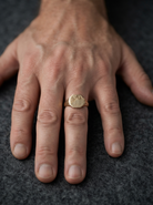 hand A 9 carat gold gentlemans signet ring. The head is eight sided, half hand engraved, measures 11.9x11.9mm, weight 2.3grams.