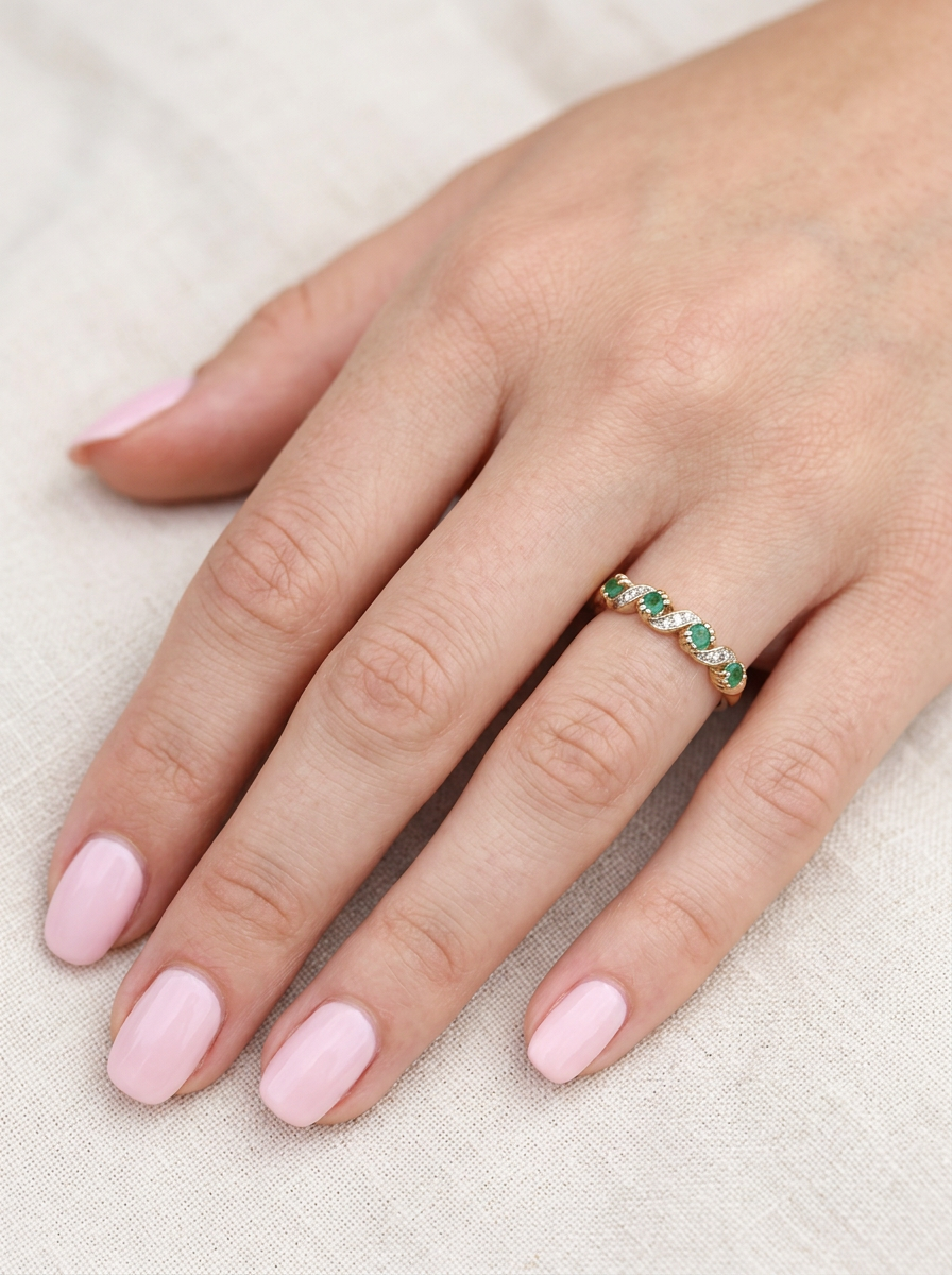 hand A 9 carat gold half hoop eternity ring. Set with four 2.4mm emeralds.

Set in alternate sections, a 'lazy S' design,