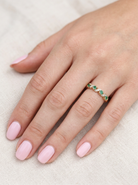 hand A 9 carat gold half hoop eternity ring. Set with four 2.4mm emeralds.

Set in alternate sections, a 'lazy S' design,