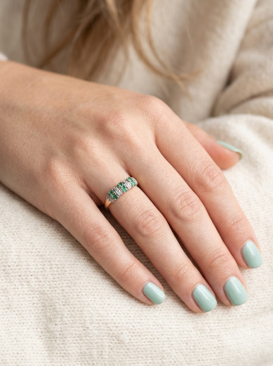 hand A 9 carat gold half hoop ring. Set with six round emeralds 3mm each,(total 0.35 carats est) and interspaced with vertical white gold sections each set with 1mm diamonds.(0.05 carats est)