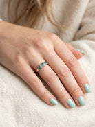 hand A 9 carat gold half hoop ring. Set with six round emeralds 3mm each,(total 0.35 carats est) and interspaced with vertical white gold sections each set with 1mm diamonds.(0.05 carats est)