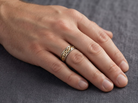 hand A 9 carat two colour gold ring. The centre band yellow gold, celtic design, the outer rims are white gold.&nbsp;