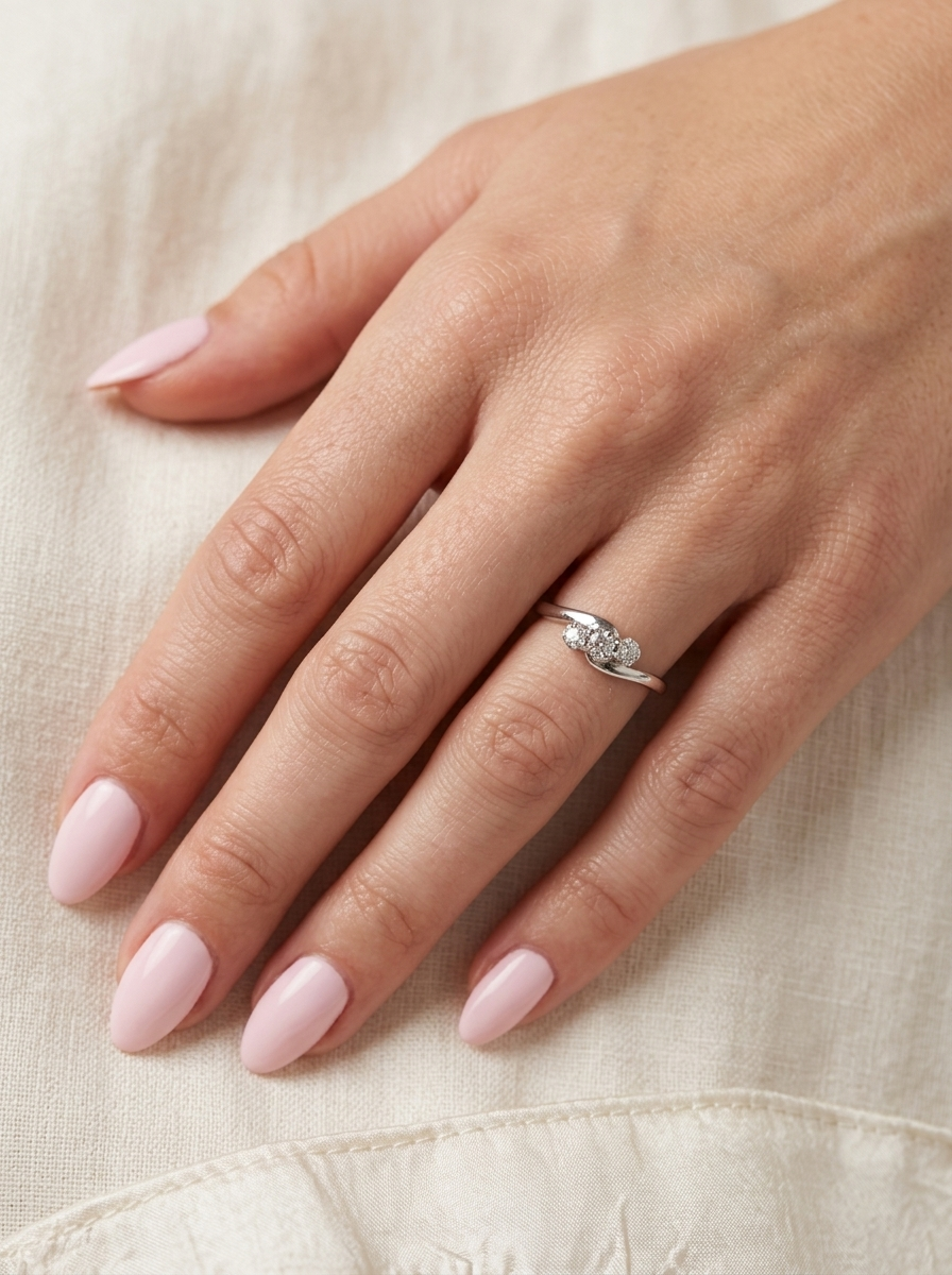 hand A 9 carat white gold cross over style trilogy ring. Three x 0.10mm diamonds, to an estimated at 0.30 carats.