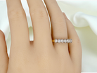 hand A fine 18 carat gold half hoop eternity ring, beautifully set with an array of seven brilliant-cut white diamonds.