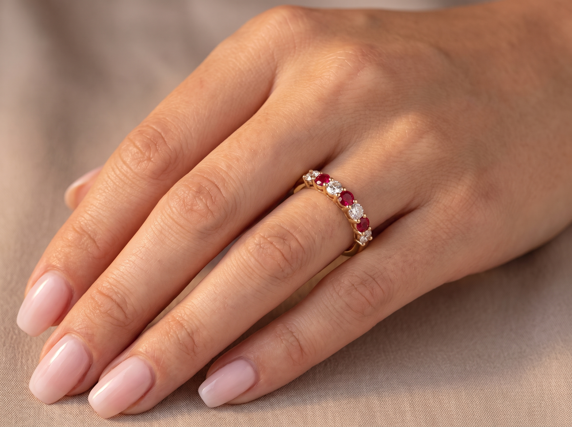 hand A fine half hoop ring. 18 carat gold set with three rubies, each 3.8mm (est 0.20 carats, total 0.67 carats) and four brilliant cut white diamonds, each 3.8mm (total 0.85 carats)&nbsp;
