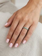 hand A fine platinum half hoop eternity ring. This is a new ring*. Channel set gem stones, five bright green emeralds 2.6mm each (0.54 carats total)