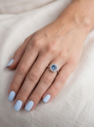 hand A fine vintage cluster ring centred with a deep blue aquamarine, measuring approximately 8mm and estimated at 2 carats, securely claw set.