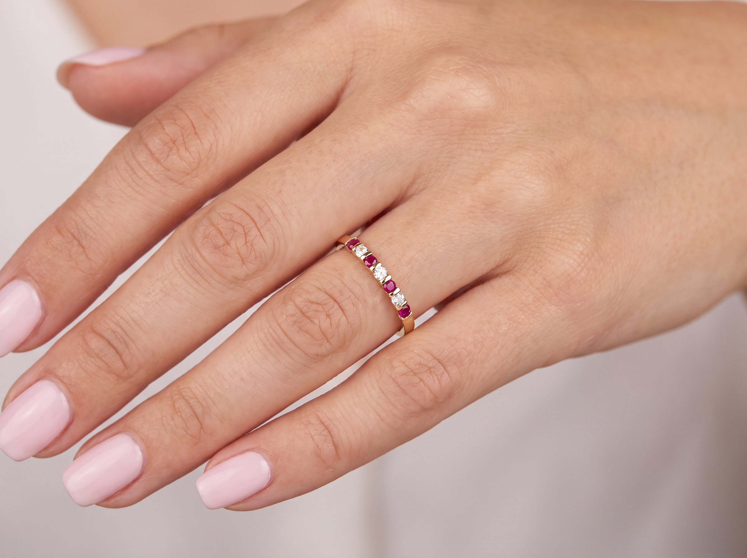 hand A half hoop 18 carat yellow gold eternity ring. Set with four bright red rubies, each 2.6mm (total carat weight 0.28 est)