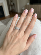 hand A lovely 18 carat white gold half hoop ring. Set with a middle row of nine bright white brilliant cut diamonds, graduate from 2.2mm to 2.6mm. The top and bottom rows are also set with small diamonds.