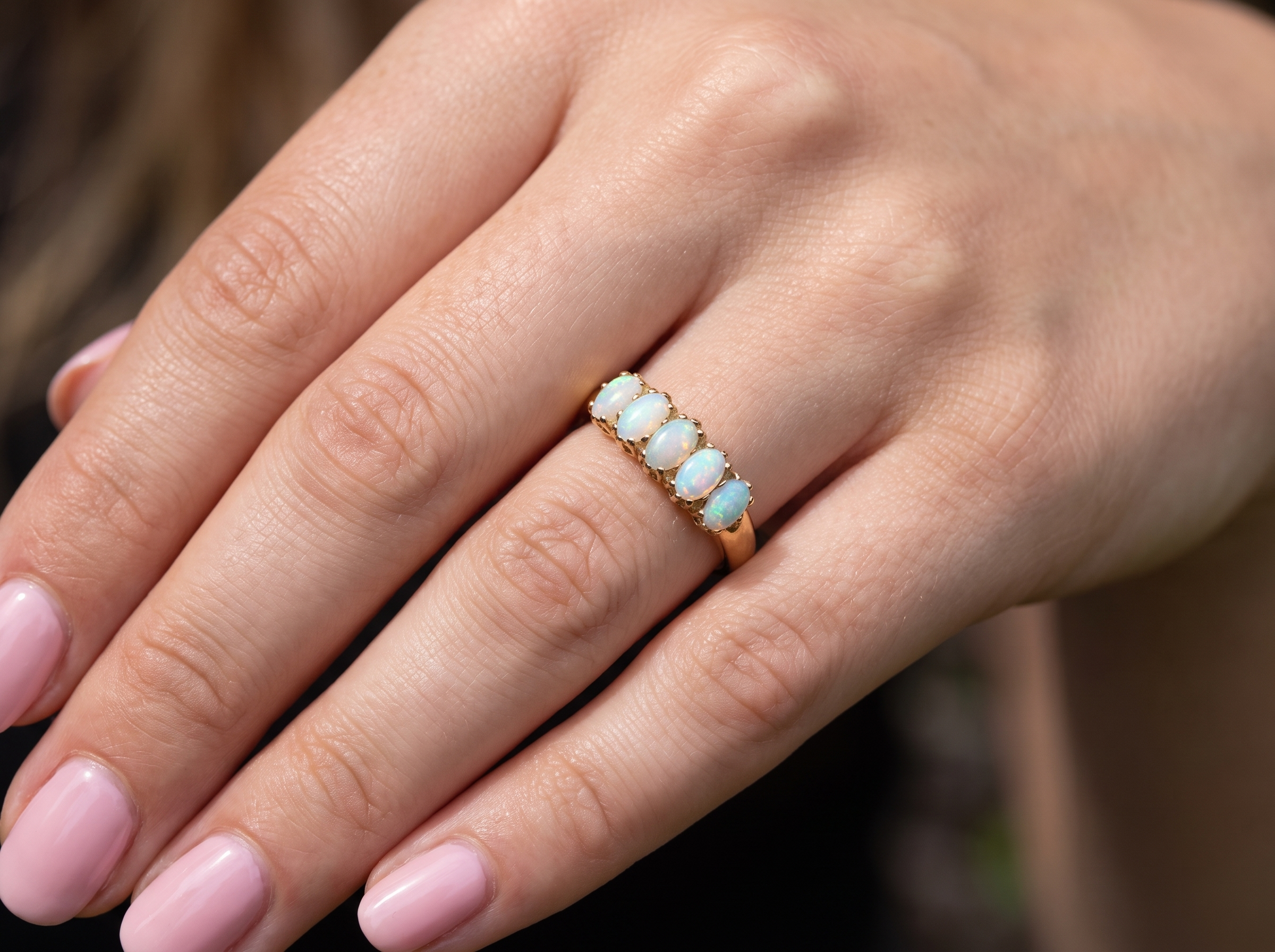 hand A lovely five stone ring. Set with five oval white opals, each 5x3.5mm, good play of colour on all.

Carved head 