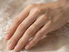 hand A narrow 18 carat gold wedding ring bead pattern