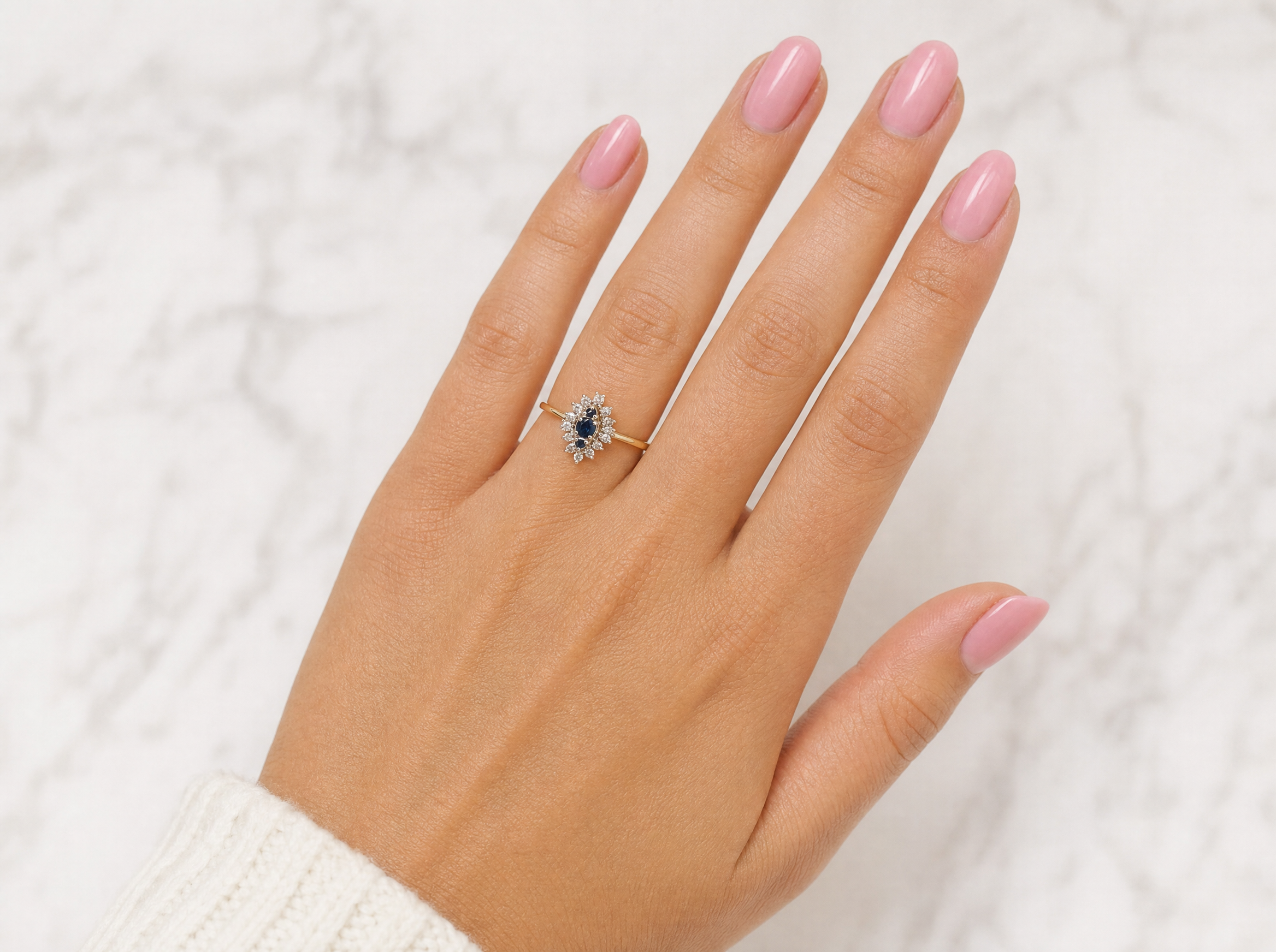 hand A navette shaped cluster ring. The centre a line of three sapphires, 0ne x 3.5mm, 2 x 1.5mm.
