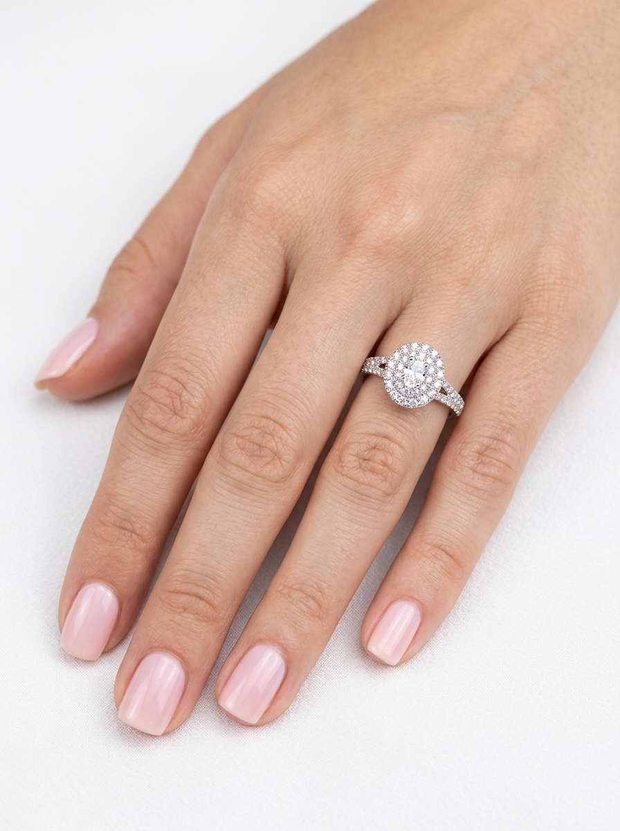 hand A new diamond cluster ring* An oval diamond halo cluster ring. Set with brilliant cut white diamonds, colour H-k, clarity Si.