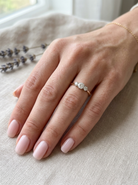 hand A pretty three stone trilogy ring that features three brilliant cut white diamonds.

Centre diamond, 5mm (est 0.50 carats) each side a 4mm diamond (est 0.25 carats). Colour G-h, clarity Si. Platinum rim style setting, head measures 12.7x5.3mm, depth 5.3mm, weight 2.4grams.