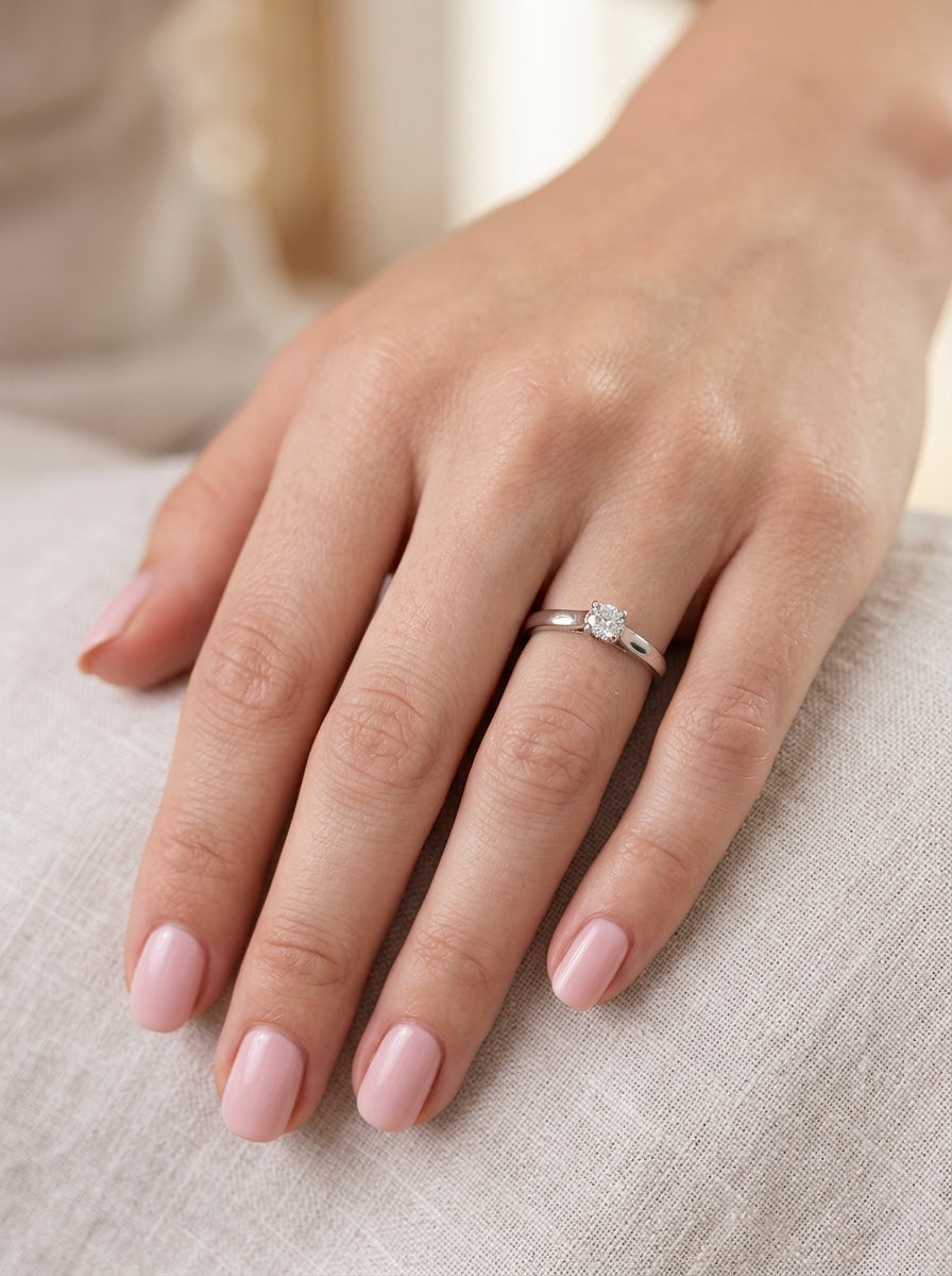 hand A single stone solitaire diamond ring. The modern brilliant cut white diamond measures 3.9mm (0.22 carats est) Colour G-h, clarity VS.
