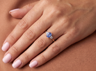 hand A three stone 18 carat gold ring. Features a rectangular tanzanite centre stone 6x4mm (est 0.50 carats)