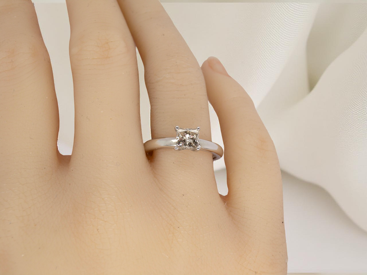 hand A timeless and beautifully crafted solitaire ring featuring a stunning 0.78 carat Princess-cut white diamond 