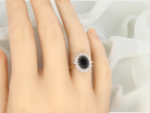 hand A timeless cluster ring featuring a deep ink-black blue sapphire 