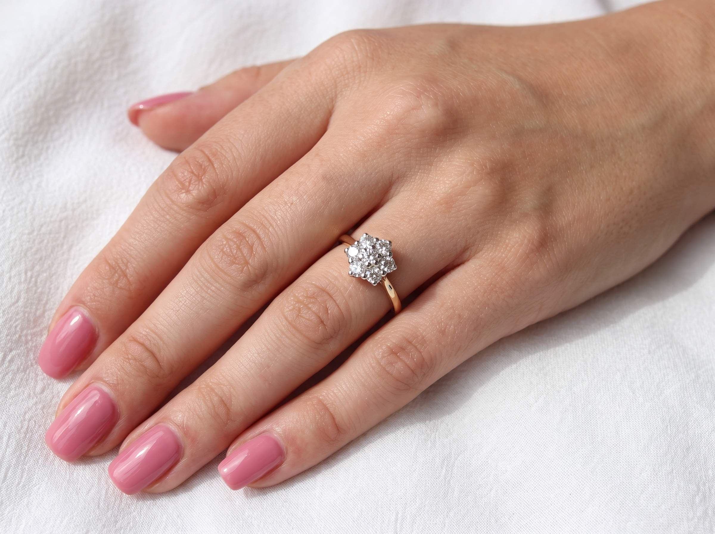 hand A traditional cluster ring. Features to the centre a 3.4mm brilliant cut white diamond (est 0.15 carats)

Surrounded by six 3.4mm diamonds to match