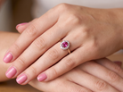 hand A traditional cluster ring. Features to the centre a dark pink red ruby, oval cut 6x4mm (0.50 carats)