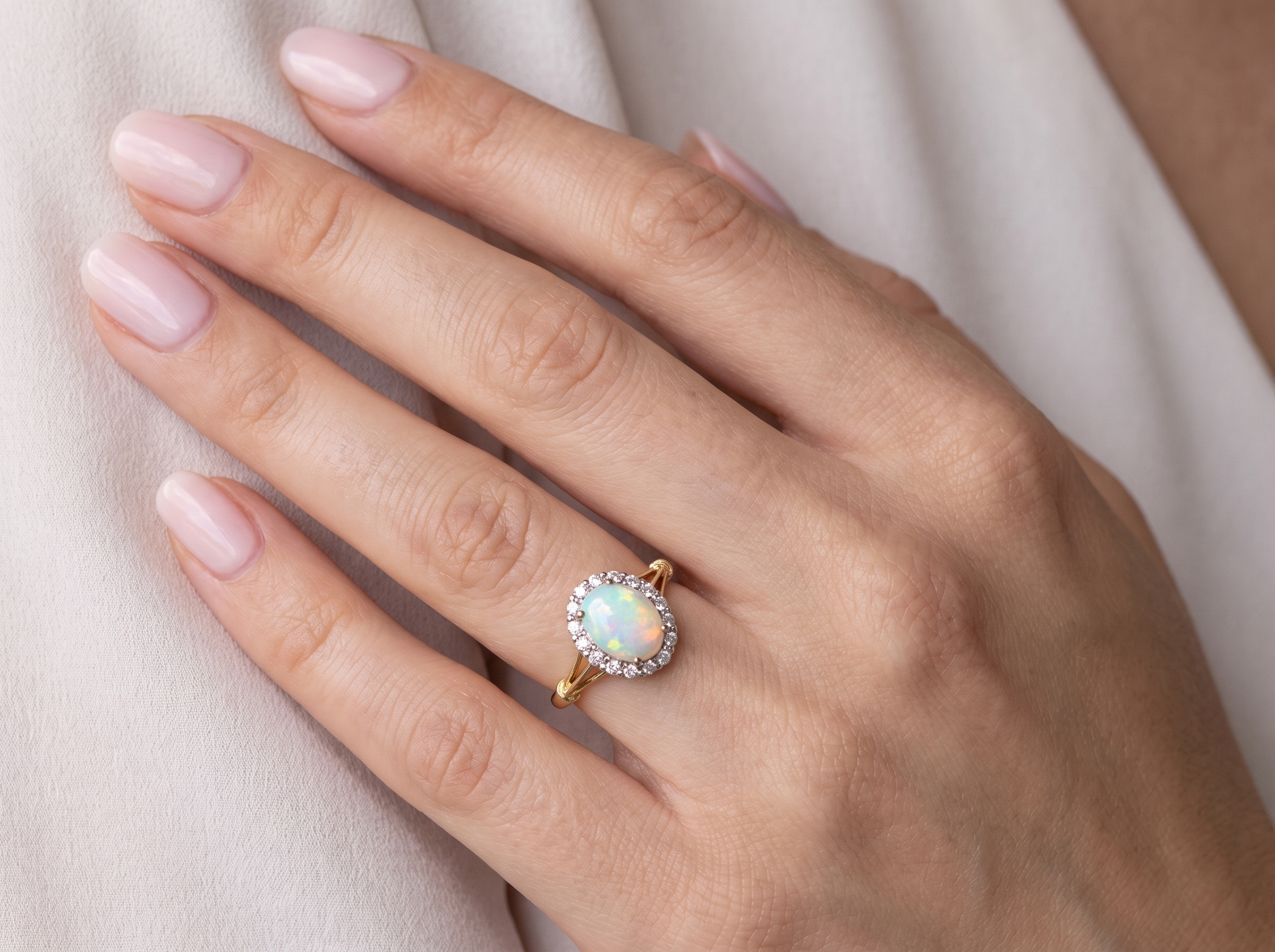 hand A vintage cluster ring. Features an oval white opal, measures 10x8mm, with a good play of colour.