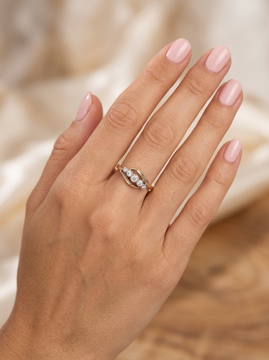 hand A vintage cross over style ring. Set with five old brilliant cut white diamonds. Centre stone 3mm, each side 2.4mm, each end 1.5mm. Total diamond content estimated at 0.22 carats.
