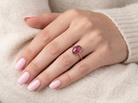 hand A vintage dress ring. Set with an oval cabouchon cut garnet, 11x7mm, in a rim style setting.