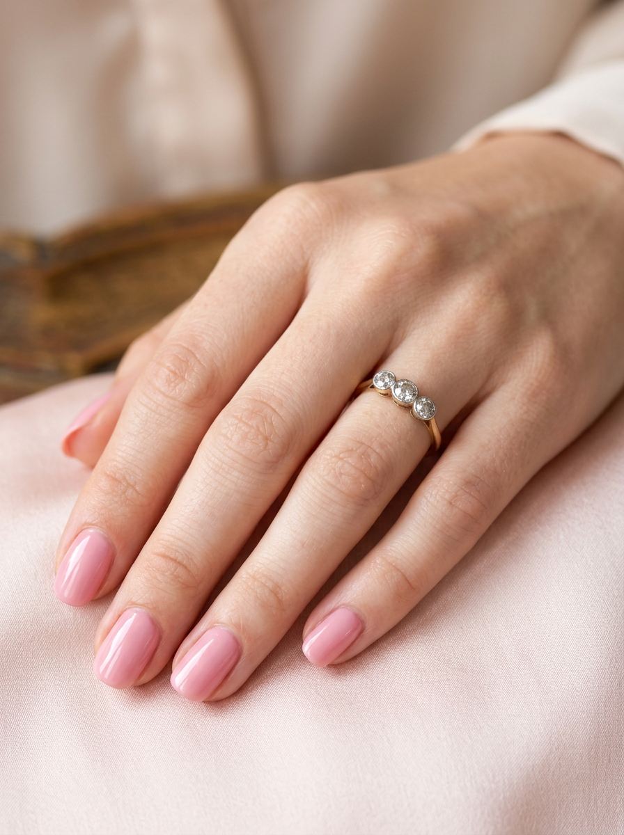 hand A vintage early 20th century trilogy ring. Set with three old cut diamonds, centre stone 3.8mm, and each side a 3.6mm diamond (total carat weight estimated at 0.55 carats)
