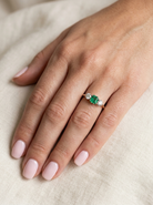 hand A vintage trilogy ring. Centre stone a step cut emerald, 6.5x5.5mm (est .75 carats). The emerald is dark green. 