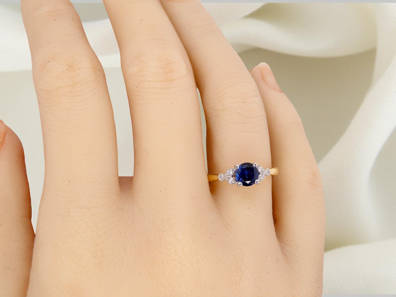 hand An 18 carat gold ring set with a vibrant blue sapphire, 
