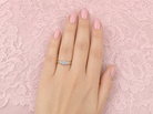 hand An 18 carat gold trilogy ring. Set with a total of twelve Princessa cut white diamonds, the centre portion measures 5x5mm, each side a 4.5x4.5mm setting,